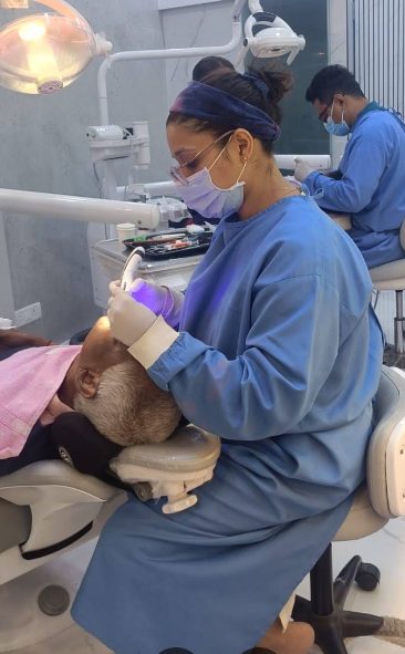 Dentist treating a patient in the clinic's treatment room